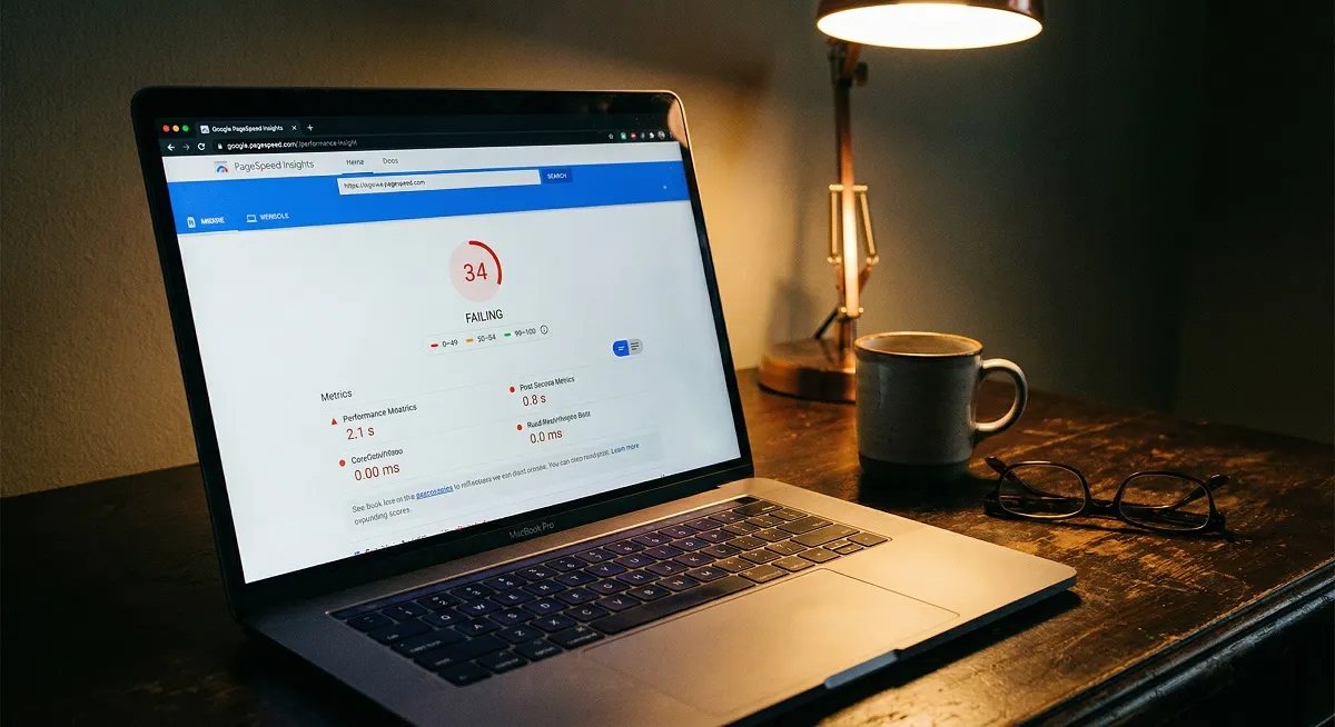 Google PageSpeed Insights showing poor website performance score on laptop screen at office desk