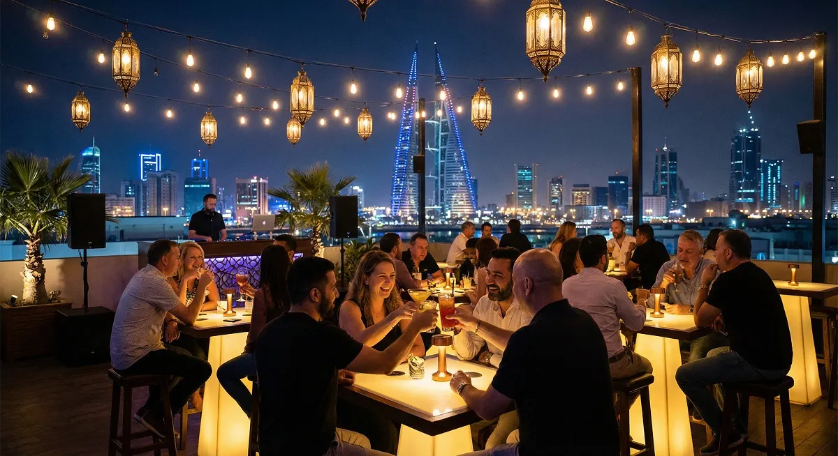 Rooftop bar in Bahrain at night with socializing guests and city skyline glowing in background